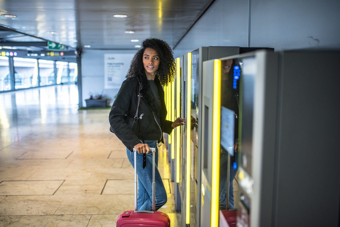 Woman paying at the parking machine at an airport.