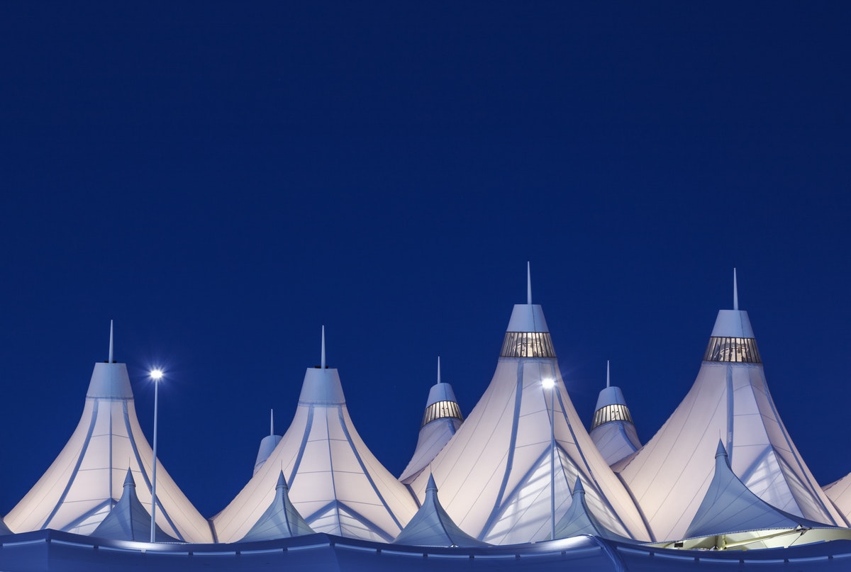 Peaked roof of Denver International Airport at nighttime.