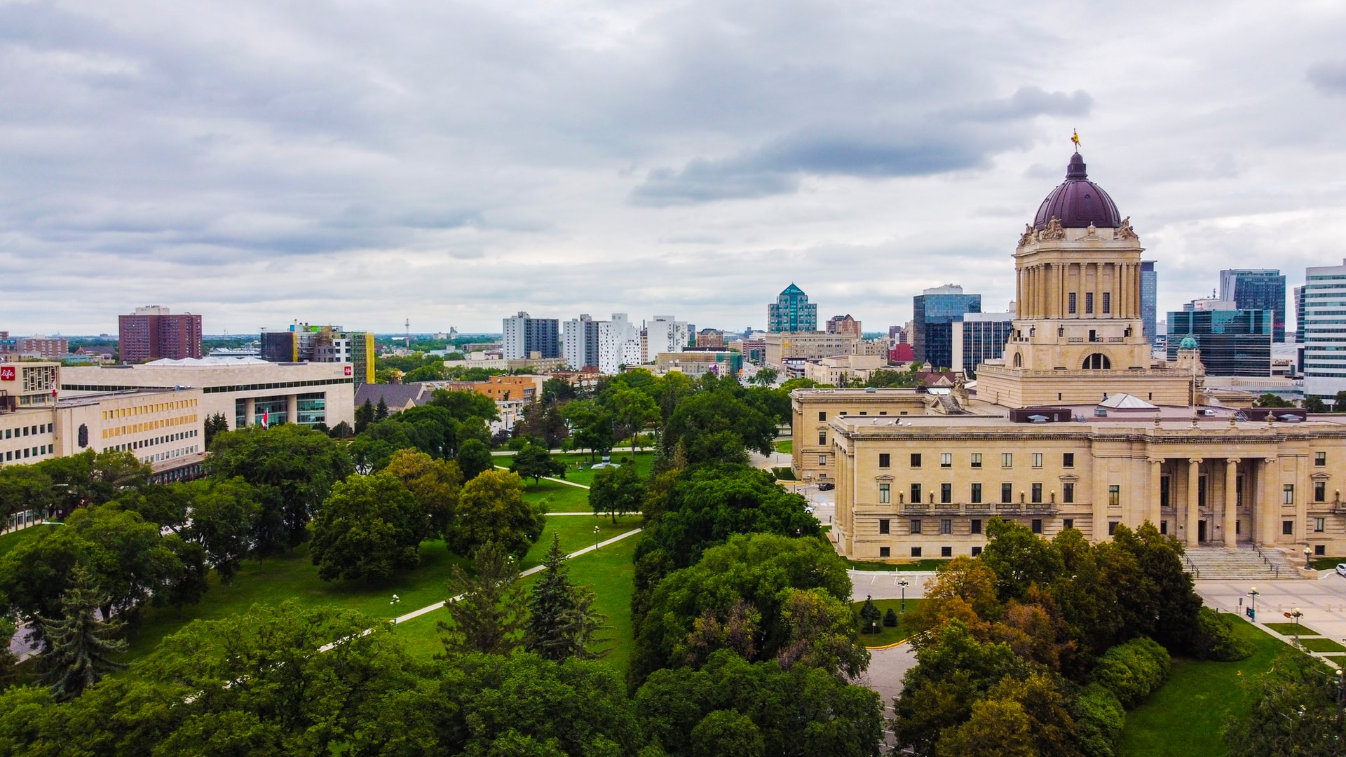 Manitoba legislature next to green trees.